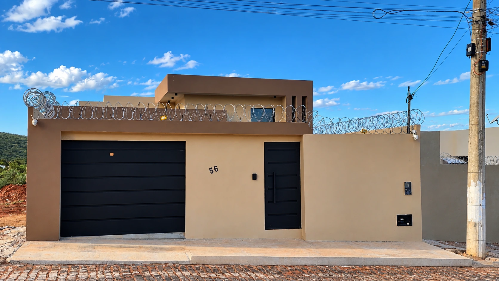 Fachada residencial em tons claros com portões pretos
